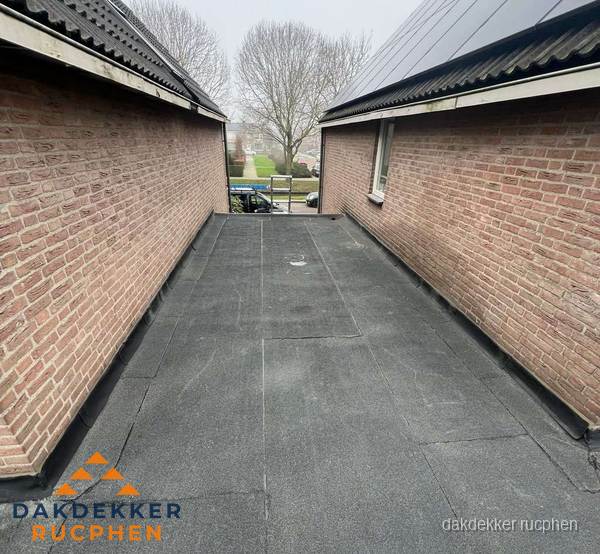 Plat dak met bitumen dakbedekking tussen bakstenen muren in Rucphen Plat dak met bitumen dakbedekking tussen bakstenen muren in Rucphen