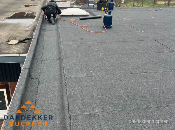 Dakdekker repareert bitumen dakbedekking op groot plat dak in Rucphen Dakdekker repareert bitumen dakbedekking op groot plat dak in Rucphen